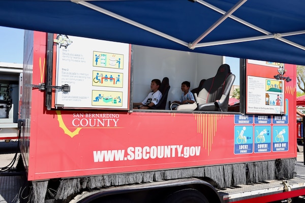 A military family experiences San Bernardino County Emergency Services’ earthquake simulator at the Emergency Preparedness and Suicide Awareness Event Sept. 10 at the Marine Corps Air Ground Combat Center. The event provided active-duty service members, their families and civilian personnel with resources and education on mental health, suicide prevention and emergency preparedness, emphasizing the importance of resilience, readiness and a culture of mutual support across the installation community (U.S. Navy photo by Christopher C. Jones, NHTP/NMRTC Twentynine Palms public affairs officer).