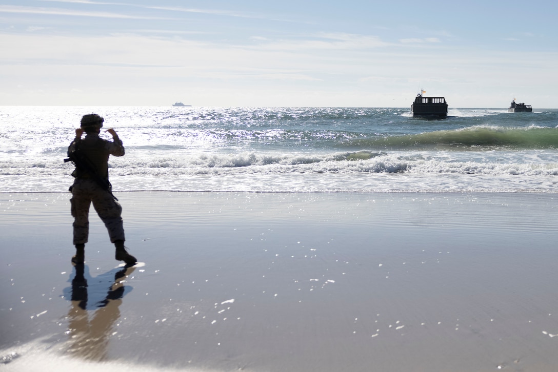 Marino Manuel Gomez Orihuela, a marine with Infantería de Marina (Spanish marine corps), directs incoming landing craft mechanized at Onslow Beach, in preparation to execute exercise UNITAS 2025, Marine Corps Base Camp Lejeune, North Carolina, Sep. 12, 2025. UNITAS, which is Latin for “unity,” was conceived in 1959 and has taken place annually since first conducted in 1960. This year marks the 66th iteration of the world’s longest running annual multinational maritime exercise. (U.S. Marine Corps photo by Lance Cpl. Payton Goodrich)