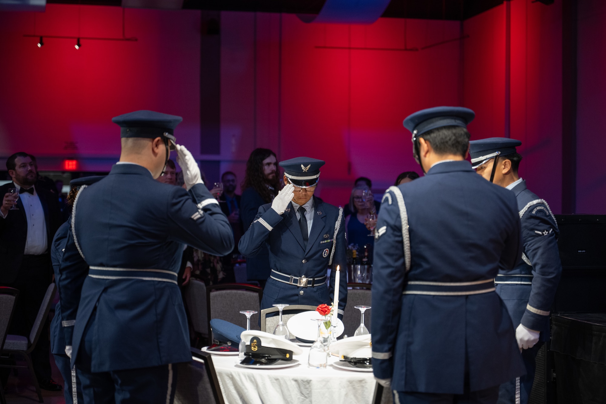Dyess Honor Guard members render honors at the POW/MIA Missing Man table during the Dyess Air Force Ball at the Abilene Convention Center, Abilene, Texas, Sept. 6, 2025. The tradition honors prisoners of war and those missing in action. (U.S Air Force Photo by Airman 1st Class Caleb Schellenberg)