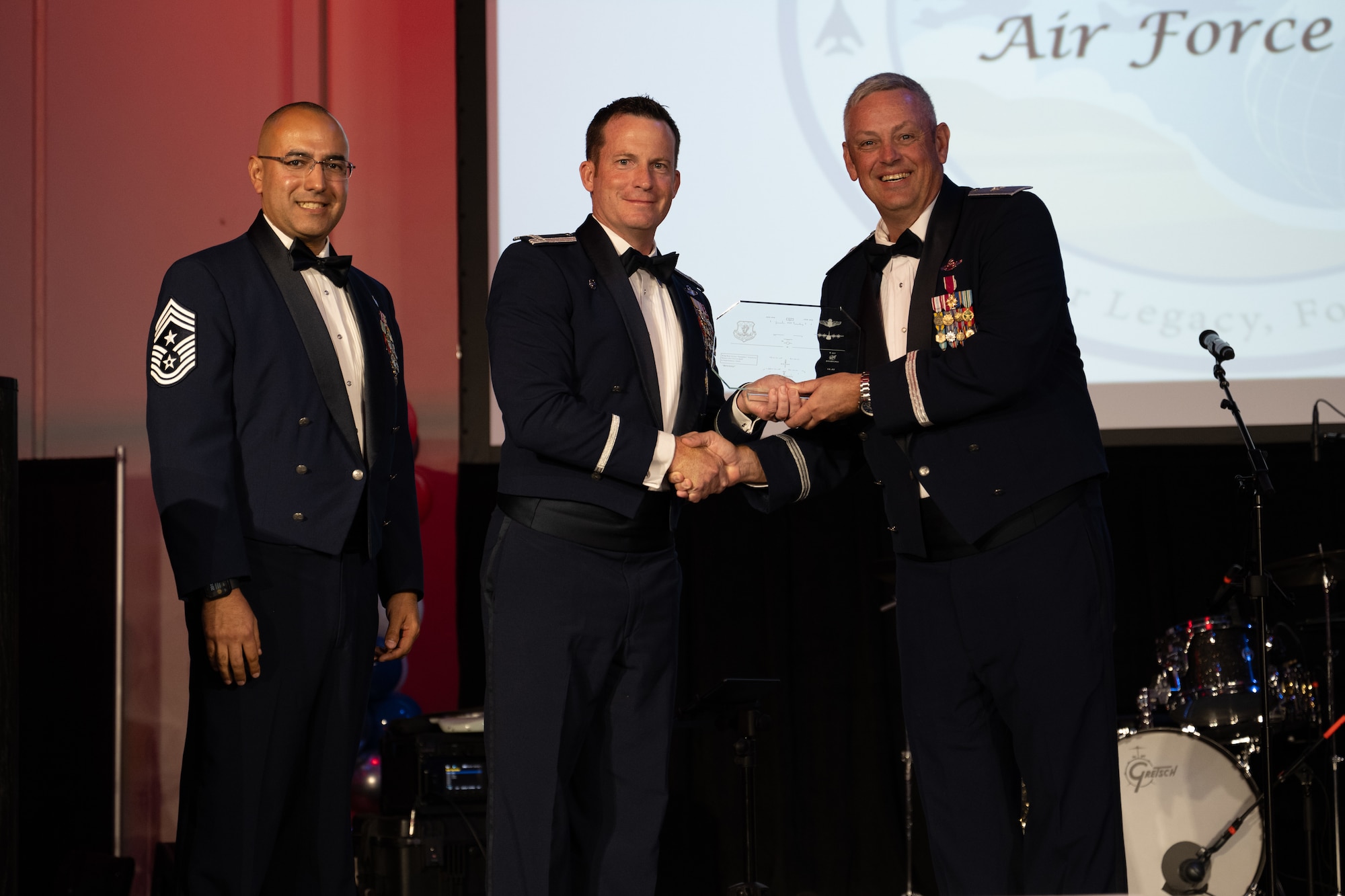 U.S. Air Force Chief Master Sgt. Martin Castillo, 317th Airlift Wing command chief, and Col. Justin Diehl, 317th AW commander, present a token of appreciation to Brig. Gen. Corey Simmons, Air Mobility Command director of strategy, plans, programs and requirements, during the Dyess Air Force Ball at the Abilene Convention center, Abilene, Texas, Sept. 6, 2025. The event celebrated the Air Force’s 78th birthday. (U.S Air Force Photo by Airman 1st Class Caleb Schellenberg)
