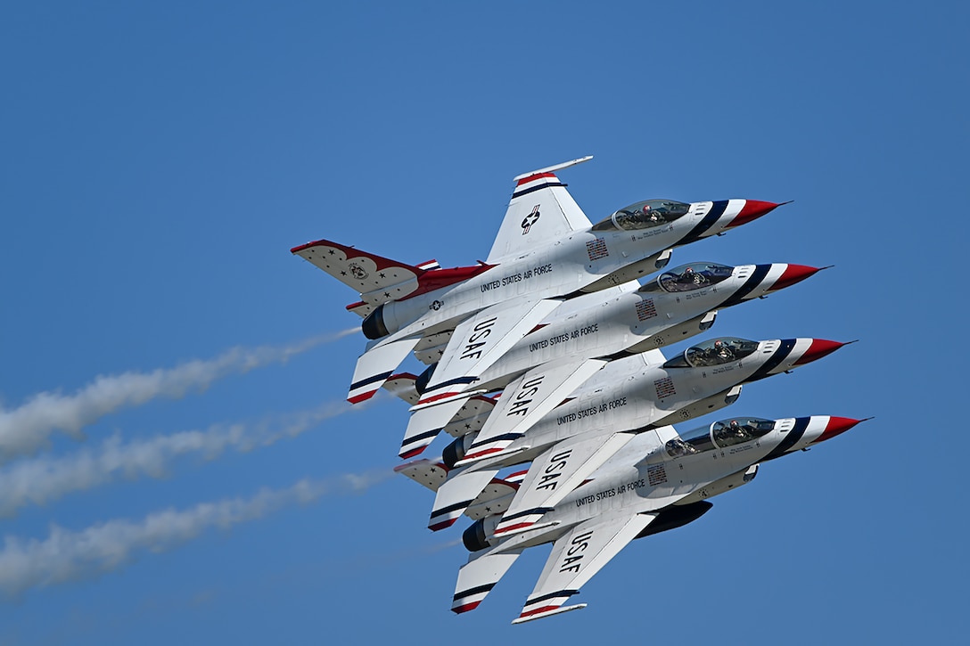 Four white jets with red and blue detailing fly together in a line.