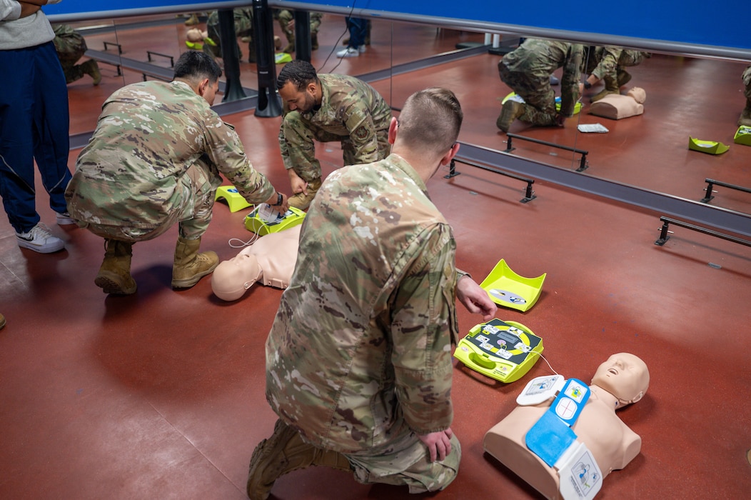 U.S. Air Force Senior Airman Nicolas Vazquez demonstrates how to use an automated external defibrillator on a training mannequin during a training on Scott AFB.