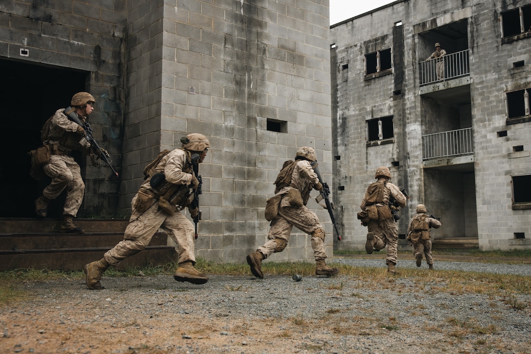 U.S. Marine Corps students with Company C, Basic Officer Course 3-25, The Basic School, run toward a building during a platoon raid as part of the Military Operations on Urban Terrain portion of a field exercise on Marine Corps Base Quantico, Virginia, Sept. 10, 2025. The purpose of the simulated platoon attacks was to introduce Marines to the fundamentals of MOUT training, evaluate their leadership in high-stress environments, and develop them into confident, provisional rifle platoon commanders. (U.S. Marine Corps photo by Cpl. Joshua Barker)