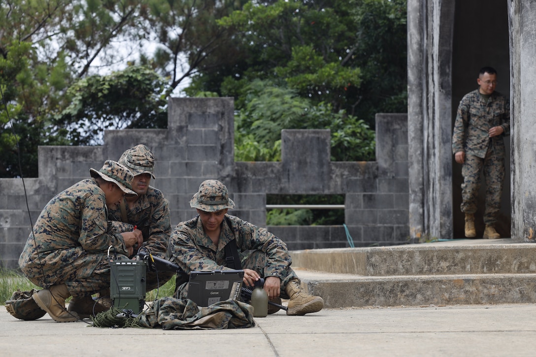 U.S. Marine Corps 2nd Lt. Vincent Rivera (center), communications officer, Staff Sgt. Andy Delgado (left), reservist communications chief, and Lance Cpl.  Christopher Bravo (right), transmissions system operator, all with 7th Communication Battalion, III Marine Expeditionary Force Information Group, set up a high frequency radio communication system outside the combat operations center in Combat Town, Camp Hansen, Okinawa Japan, Sept. 13, 2025, during the Command Post Exercise portion of Resolute Dragon 25. Resolute Dragon 25 is an annual bilateral exercise across Japan, including the southwest islands, that strengthens the command, control and multidomain maneuver capabilities of III MEF and the Japan Ground Self-Defense Force’s Western Army personnel, alongside representatives across the U.S. and Japanese Joint Force, with a focus on controlling and defending key maritime terrain. (U.S. Marine Corps photo by Gunnery Sgt. Daniel Wetzel)