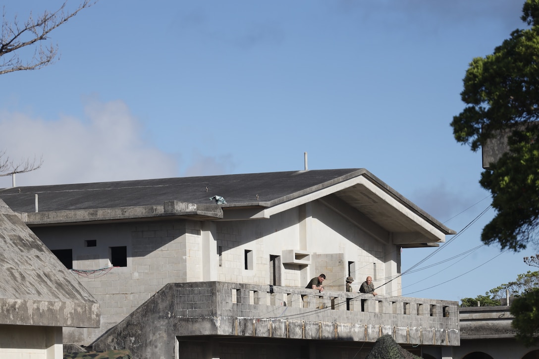 U.S. Marines and Sailors with III Marine Expeditionary Force get some air on the balconies outside their workspaces in the III MEF combat operations center in Combat Town, Camp Hansen, Okinawa Japan, Sept. 13, 2025, during the Command Post Exercise portion of Resolute Dragon 25. Resolute Dragon 25 is an annual bilateral exercise across Japan, including the southwest islands, that strengthens the command, control and multidomain maneuver capabilities of III MEF and the Japan Ground Self-Defense Force’s Western Army personnel, alongside representatives across the U.S. and Japanese Joint Force, with a focus on controlling and defending key maritime terrain. (U.S. Marine Corps photo by Gunnery Sgt. Daniel Wetzel)