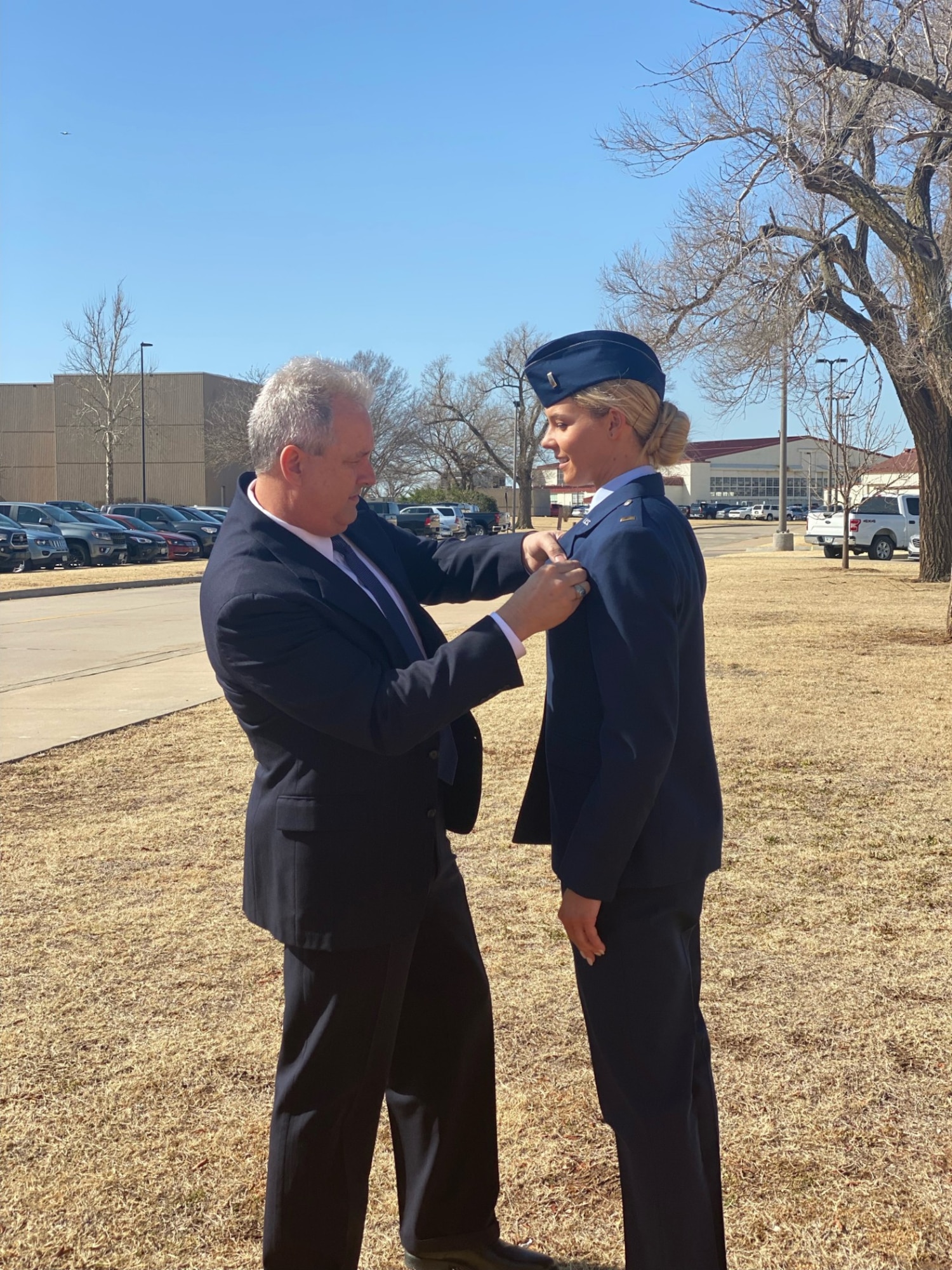 Capt. (Ret.) Robert Pickrell Jr. helps pin new pilot wings on his daughter Capt. Cassidy Pickrell at her Undergraduate Pilot Training Graduation.
