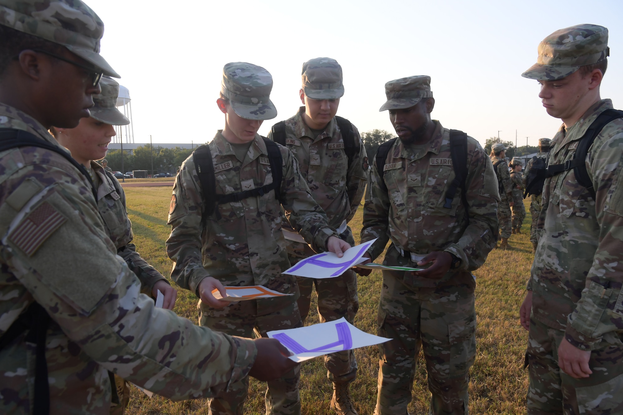 A group of people in military uniform pass around pieces of paper.