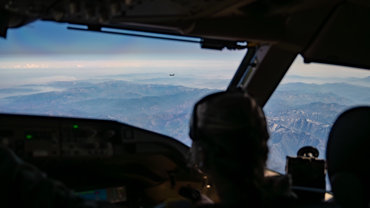 An aircraft is seen in the distance from the flight deck of another aircraft