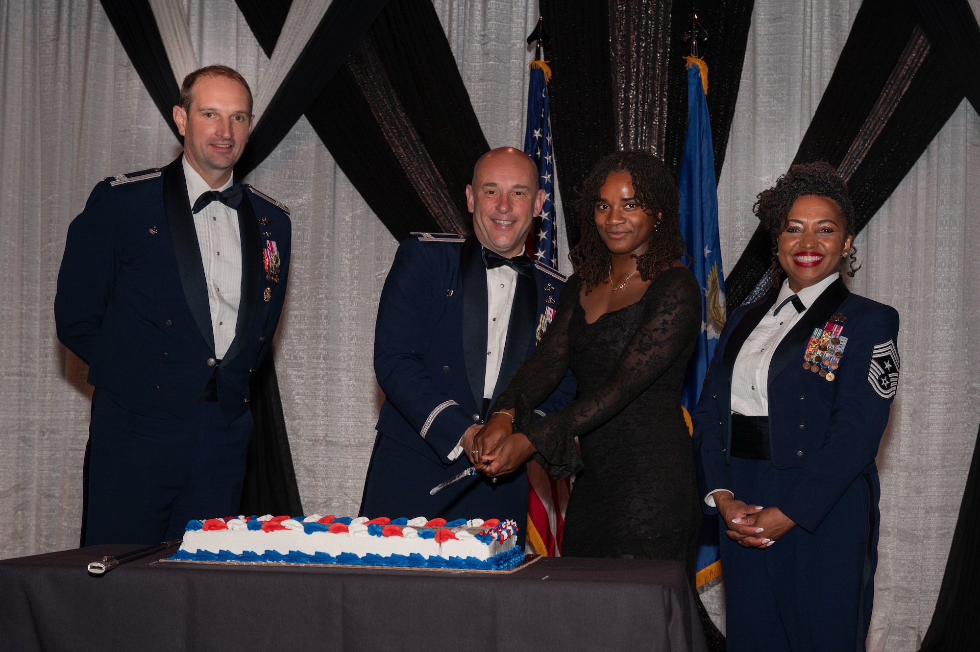 354th Fighter Wing leadership pose with the youngest and oldest Airmen from the wing as they cut a cake in honor of the United States Air Force birthday during Eielson’s Air Force Ball in Fairbanks, Alaska, Sept. 13, 2025.