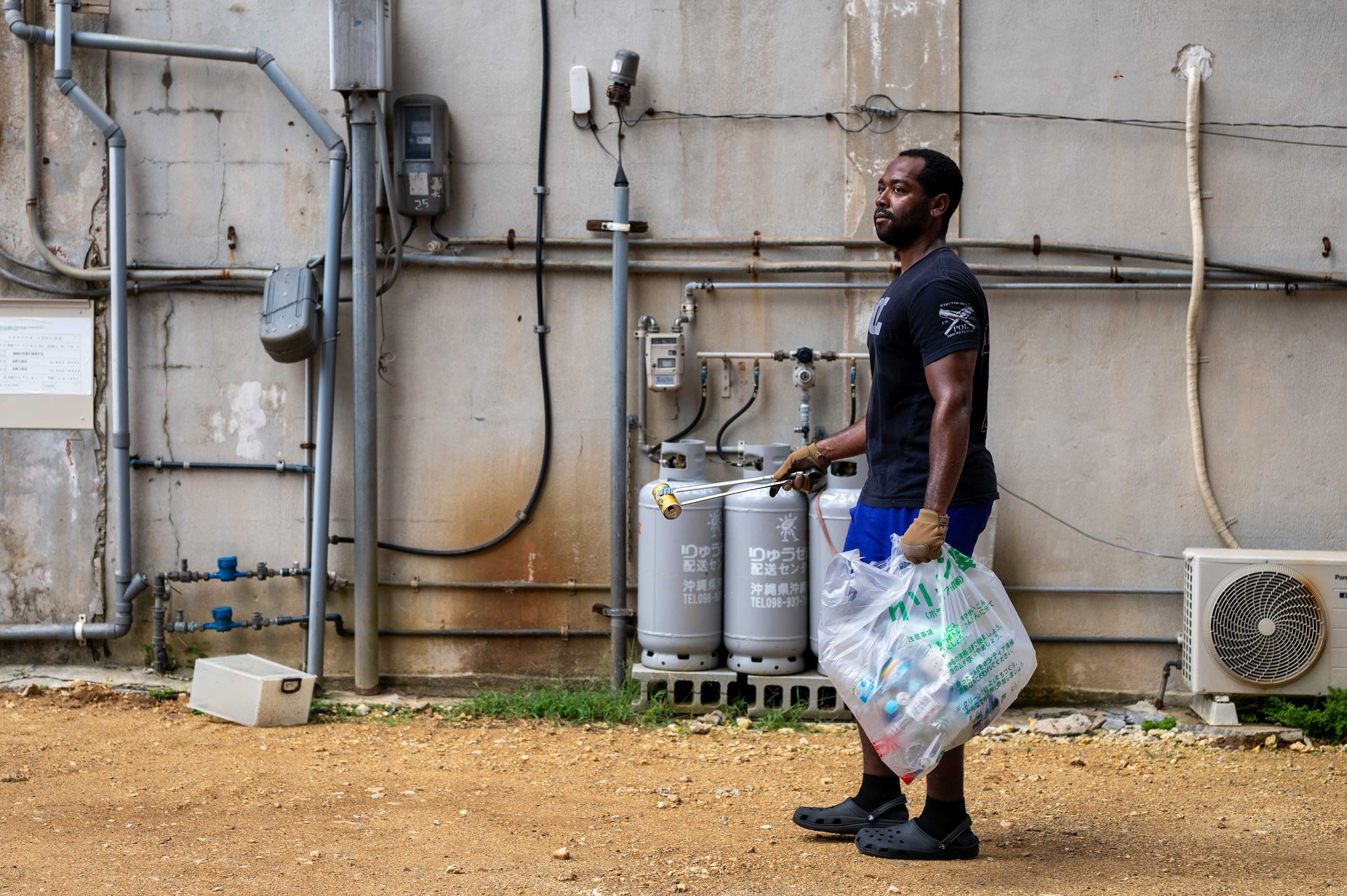 A U.S. Service member joins Okinawan volunteers to pick up trash during a bilateral community cleanup event at Kadena Air Base, Japan, Aug. 17 and 31, 2025.