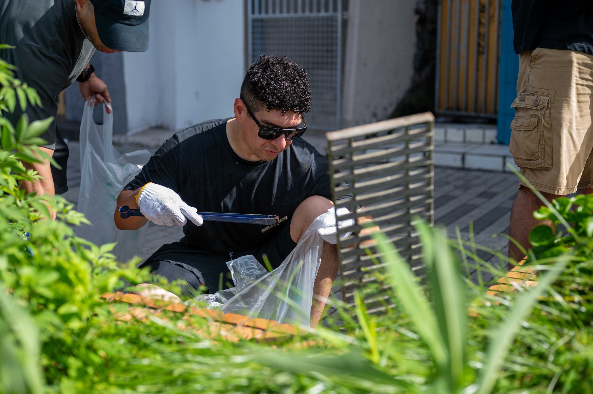 A U.S. Service member joins Okinawan volunteers to clean up city streets during a bilateral community cleanup event at Kadena Air Base, Japan, Aug. 17 and 31, 2025.