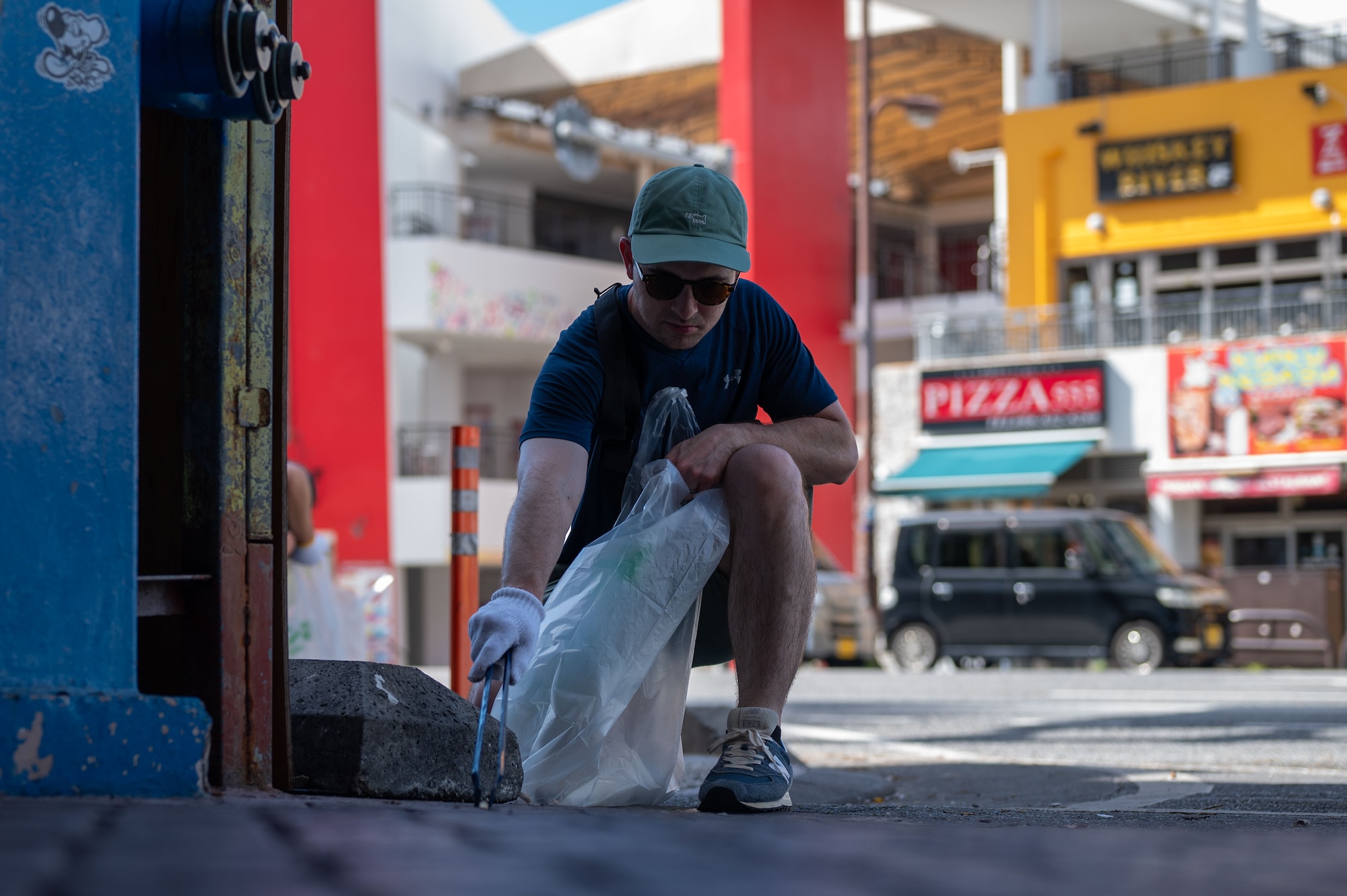 A U.S. Service member joins Okinawan volunteers to clean up city streets during a bilateral community cleanup event at Kadena Air Base, Japan, Aug. 17 and 31, 2025.