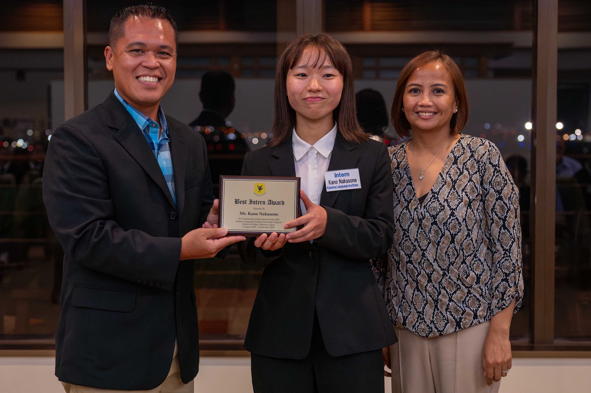U.S. Air Force Col. Robinson Mata, 18th Mission Support Group commander, presents Ms. Kano Nakasone with the best intern award at the farewell dinner after a four week internship program for Kadena Language Institute students at Kadena Air Base Japan, Aug. 27, 2025.