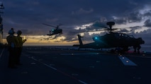 Aviation Boatswain’s Mate (Handling) 3rd Class Ashley Oscar, from Atlanta, left, and Aviation Boatswain’s Mate (Handling) Airman Korie Espenschied, from Beach City, Ohio, both assigned to the amphibious assault ship USS America (LHA 6) observe a U.S. Army AH-64E Apache Guardian helicopter from the 2nd Squadron, 6th Calvary Regiment assigned to the 25th CAB take off from the flight deck of the America during a joint aviation training exercise with the U.S. Army, boosting interoperability and readiness in the Indo-Pacific region Sept. 11