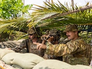 U.S. Marine Corps Capt. Erik Carlson, left, and Sgt. Ceaser Luna, both joint terminal attack controllers with Marine Rotational Force – Darwin 25.3, and Australian Army officer Lt.  Benjamin Buchanon, a Royal Australian Artillery Fire Support officer, observe a target during a close-air support rehearsal during Exercise Balikatan 25, April 26, 2025.