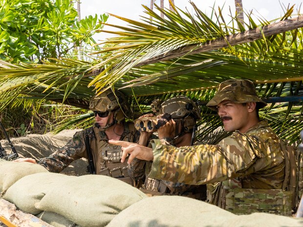 U.S. Marine Corps Capt. Erik Carlson, left, and Sgt. Ceaser Luna, both joint terminal attack controllers with Marine Rotational Force – Darwin 25.3, and Australian Army officer Lt.  Benjamin Buchanon, a Royal Australian Artillery Fire Support officer, observe a target during a close-air support rehearsal during Exercise Balikatan 25, April 26, 2025.