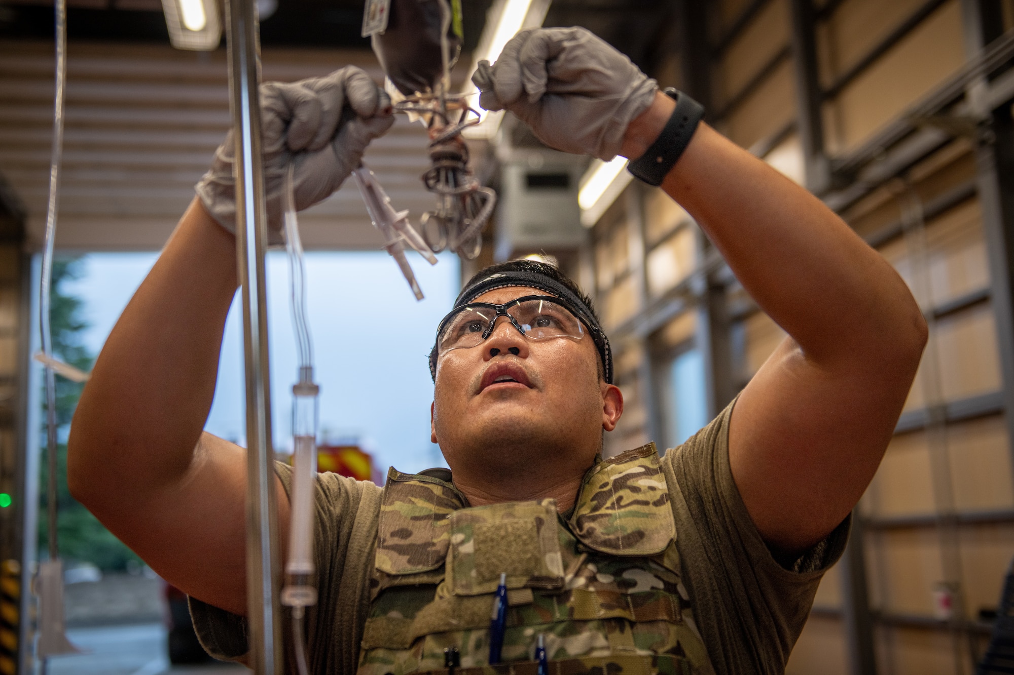 An Airman ties the ends of a blood bag.