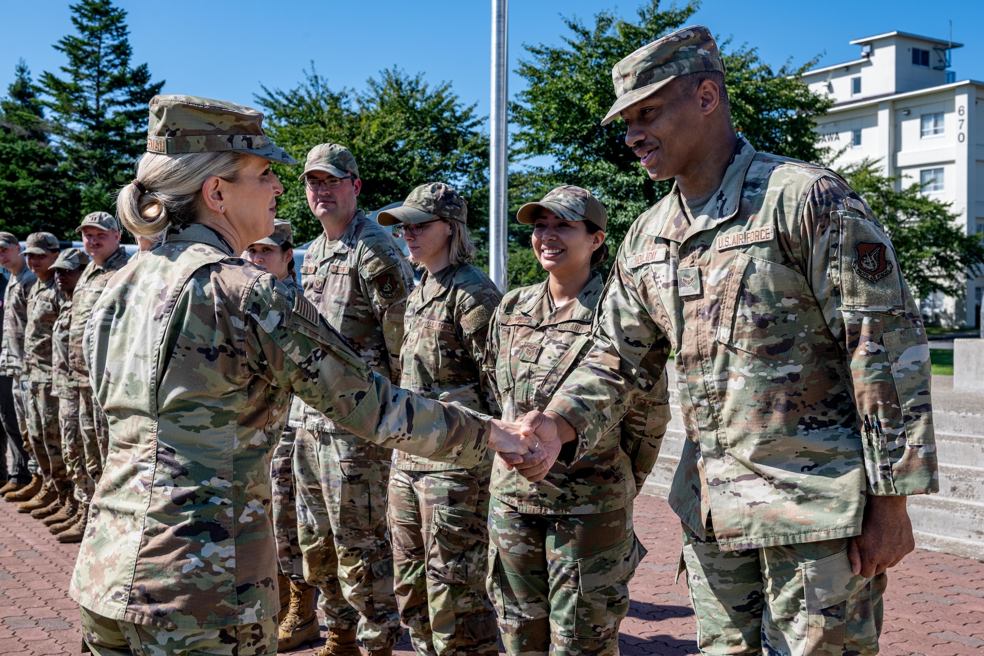 U.S. Air Force Lt. Gen. Laura Lenderman, left, Pacific Air Forces deputy commander, coins Airman 1st Class Alexander Holliday, 35th Contracting Squadron contracting specialist, during a tour.
