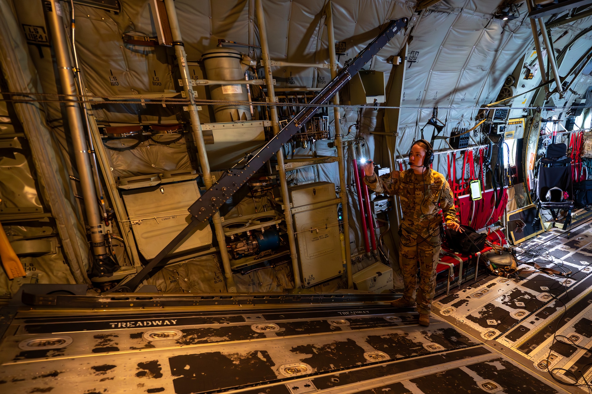 Service member inspects the aircraft in the sky.