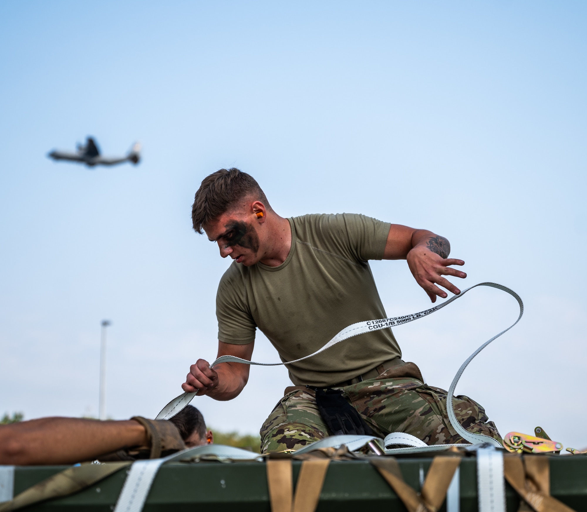 Senior Airman Bryson Pack, munitions crew chief assigned to the 86th Munitions Squadron fastens a strap on top of a supply pallet during an exercise at Ramstein Air Base
