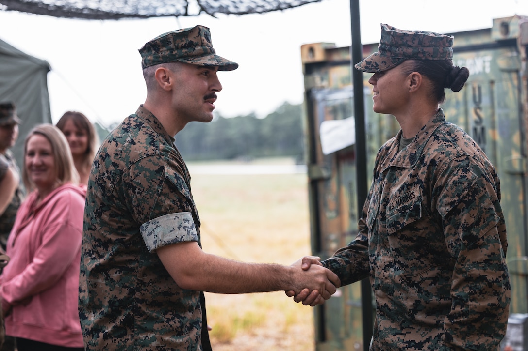U.S. Navy Lt. Cmdr. Chad Barnhart, left, the 26th Marine Expeditionary Unit surgeon and Michigan native, shakes hands with U.S. Marine Corps Sgt. Maj. Nadia Sensing, the senior enlisted leader with Combat Logistics Battalion 22, Combat Logistics Regiment 27 during his promotion ceremony at Landing Zone Falcon at Marine Corps Base Camp Lejeune, North Carolina, Sep. 14, 2025. A promotion ceremony is a formal recognition of a service member's advancement in rank and responsibilities. (U.S. Marine Corps photo by Sgt. Jorge Borjas)