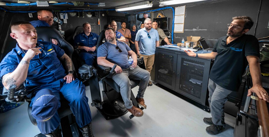 Amitai Peleg, SEALARTEC CEO, right, gives a presentation of the autonomous boat launch and recovery system in the Stiletto briefing room in Norfolk, Virginia, on June 2, 2025.