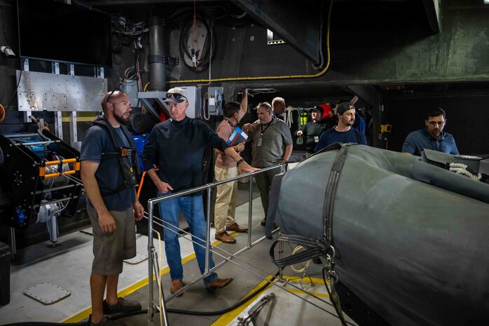Cory Sears, Stiletto Chief Engineer, left, talks with Dennis Danko, Stiletto Program Manager, right, during an autonomous boat launch and recovery in Norfolk, Virginia, on June 2, 2025.