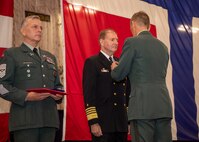 Adm. Stuart B. Munsch, commander, U.S. Naval Forces Europe-Africa, center, receives the Norwegian Defence Service Medal from Gen. Eirik Kristoffersen, Norwegian Chief of Defence aboard the world’s largest aircraft carrier USS Gerald R. Ford (CVN 78), during its scheduled port call to Oslo, Norway, Sept. 13, 2025.