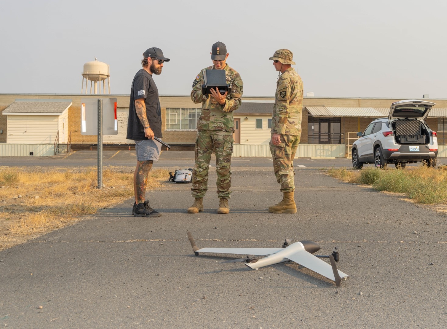 Peter DeJoseph, left, a Red Cat flight trainer, observes as Staff Sgt. First Class Gregory Mannen, center, and Staff Sgt. Timothy Powers operate the Flightwave Edge 130 unmanned aircraft system during training at the 249th Regional Training Institute, Rees Training Center, Oregon, Sept. 4, 2025.