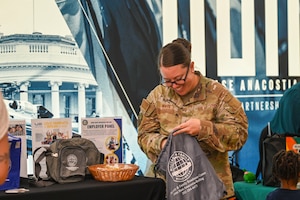 U.S. Air Force Master Sgt. Candice White, flight chief at the Military & Family Readiness Center, prepares a resource bag for guests attending the Health and Readiness Optimization Fair event at Joint Base Anacostia-Bolling, Washington, D.C., Sept. 12, 2025. This event introduced participants with 23 helping agencies that provided health and resilience resources. (U.S. Air Force photo by Airman 1st Class Shanel Toussaint)