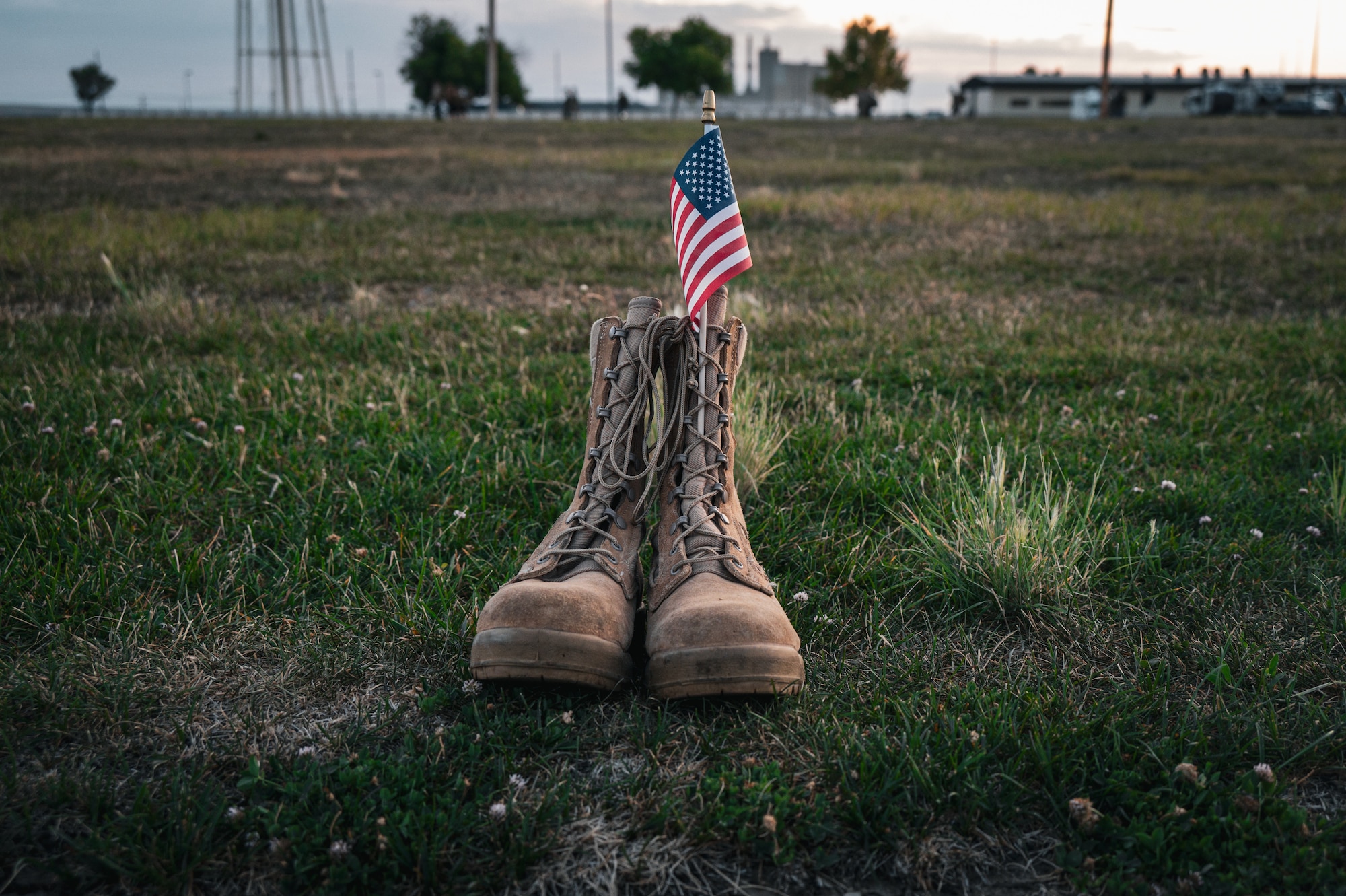 A pair of operational camouflage pattern boots sits in the grass