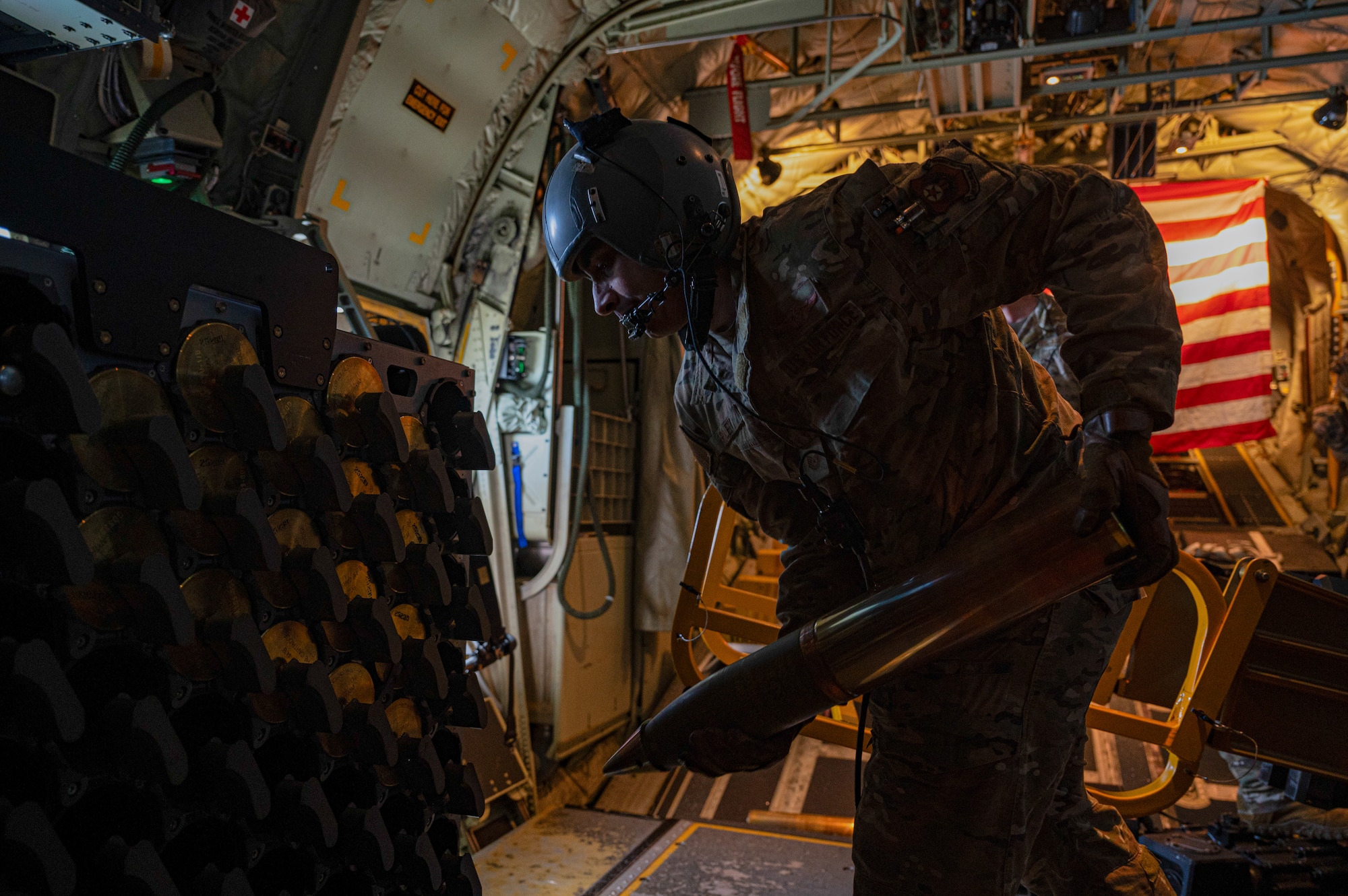 Airman unloading a 105mm round on an AC-130J