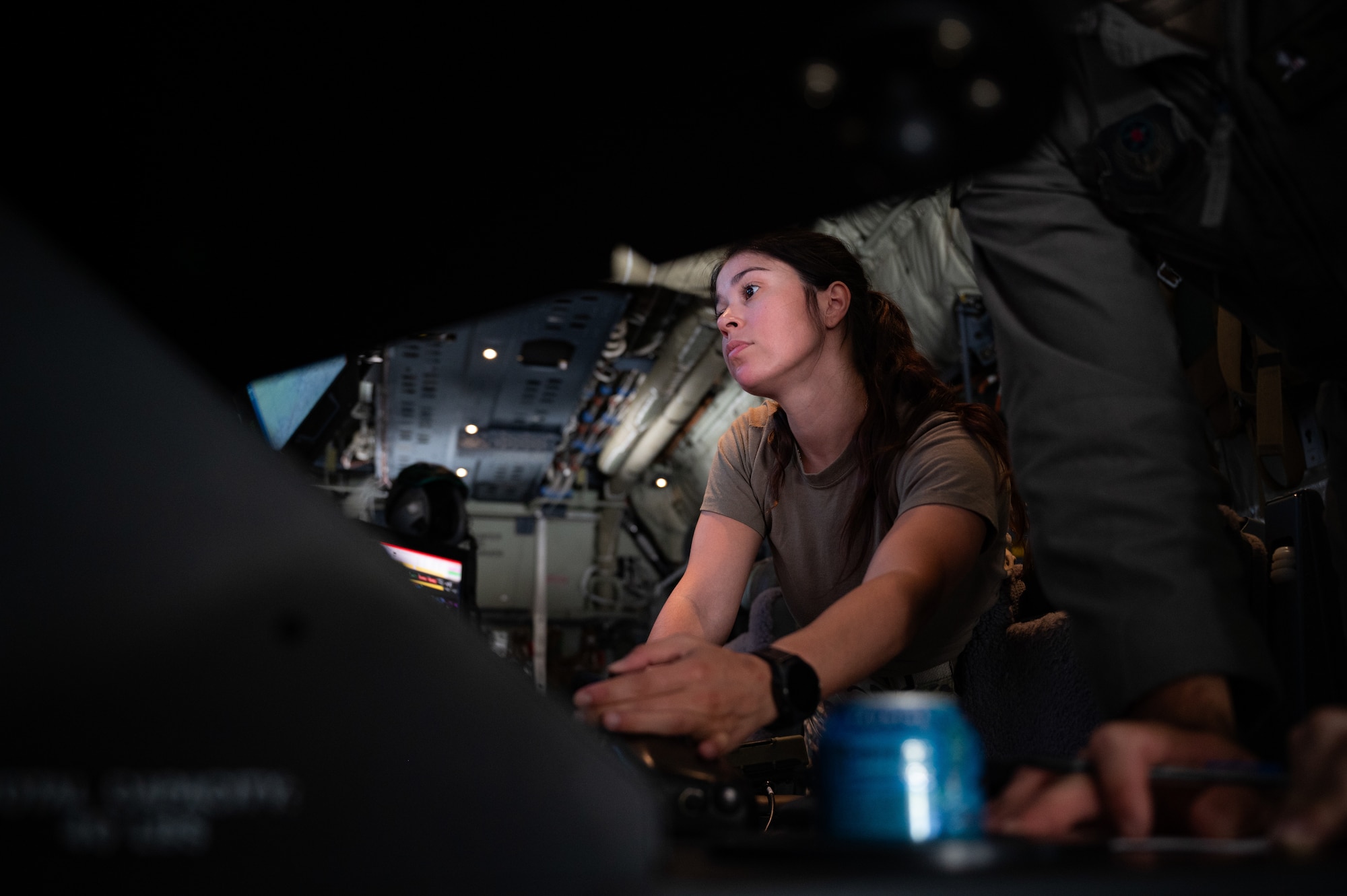 Airman sitting at a weapons station on an AC-130J