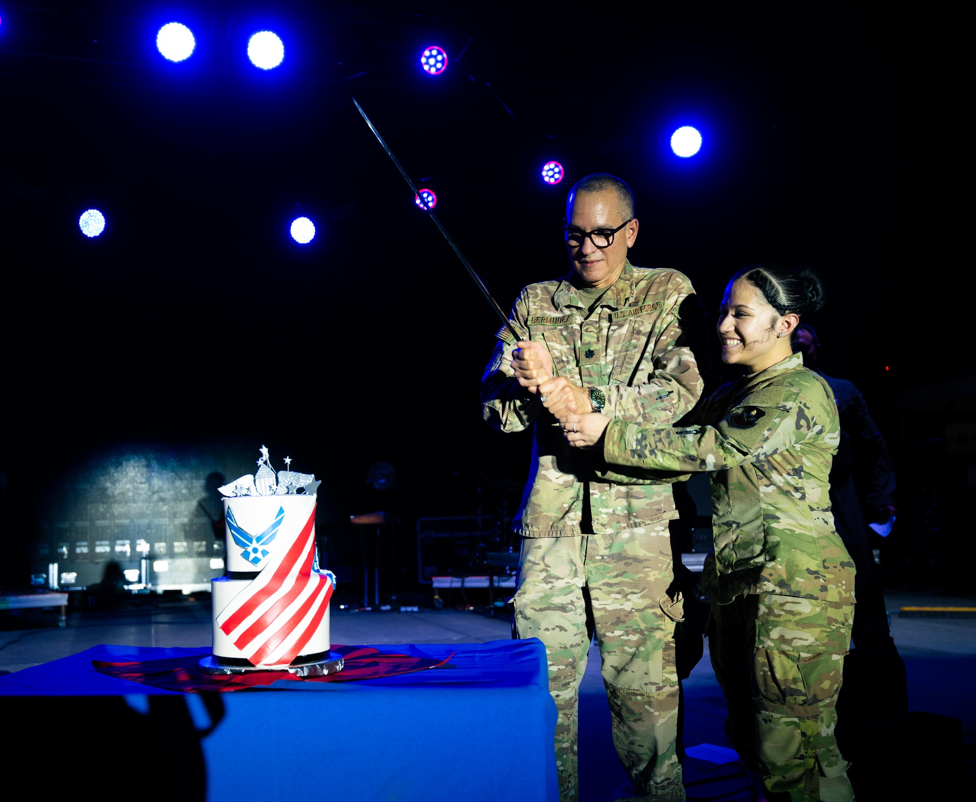 U.S. Air Force Lt. Col. Luis Bermudez, 47th Operational Medical Readiness Squadron, and Airman Nazryth Cruz, Operational Support Squadron, cut the Air Force birthday cake on the Summer Bash stage in celebration of the Air Force’s 78th birthday at Laughlin Air Force Base, Texas, Sept. 12, 2025. It is an Air Force birthday tradition to have the oldest and youngest Airmen of the Wing cut the cake, to commemorate our warrior ethos and passing of heritage across generations. (U.S. Air Force photo by Airman 1st Class Harrison Sullivan)