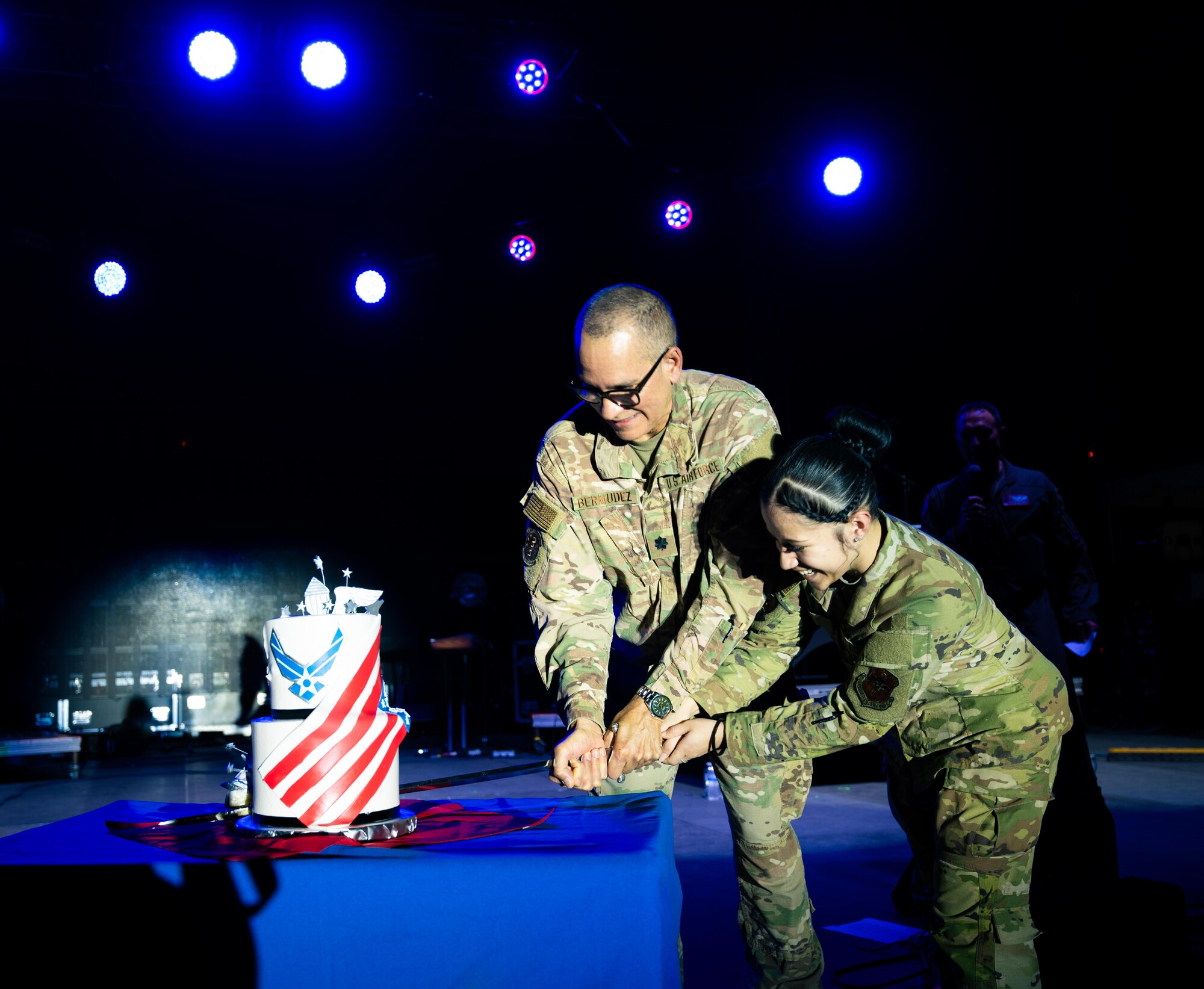 U.S. Air Force Lt. Col. Luis Bermudez, 47th Operational Medical Readiness Squadron, and Airman Nazryth Cruz, Operational Support Squadron, cut the Air Force birthday cake on the Summer Bash stage in celebration of the Air Force’s 78th birthday at Laughlin Air Force Base, Texas, Sept. 12, 2025. It is an Air Force birthday tradition to have the oldest and youngest Airmen of the Wing cut the cake, to commemorate our warrior ethos and passing of heritage across generations. (U.S. Air Force photo by Airman 1st Class Harrison Sullivan)