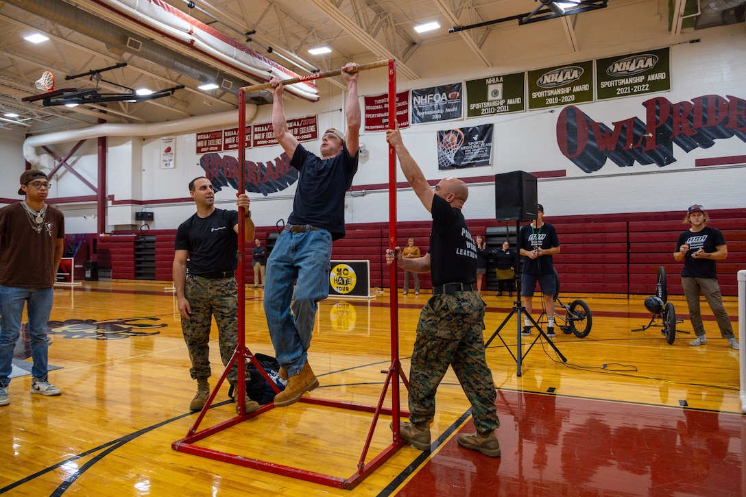 U.S. Marines with Recruiting Station Boston, Recruiting Substation Manchester, conduct a pull-up competition at the annual No Hate Tour at Timberlane Regional High School Oct. 3, 2024. The No Hate High School Tour is an impactful educational program that uses the energy and excitement of action sports to deliver critical bullying prevention tools, techniques, and information to students in a relatable, peer-to-peer manner. (U.S. Marine Corps photo by Sgt. Erin A. VandeHoef)
