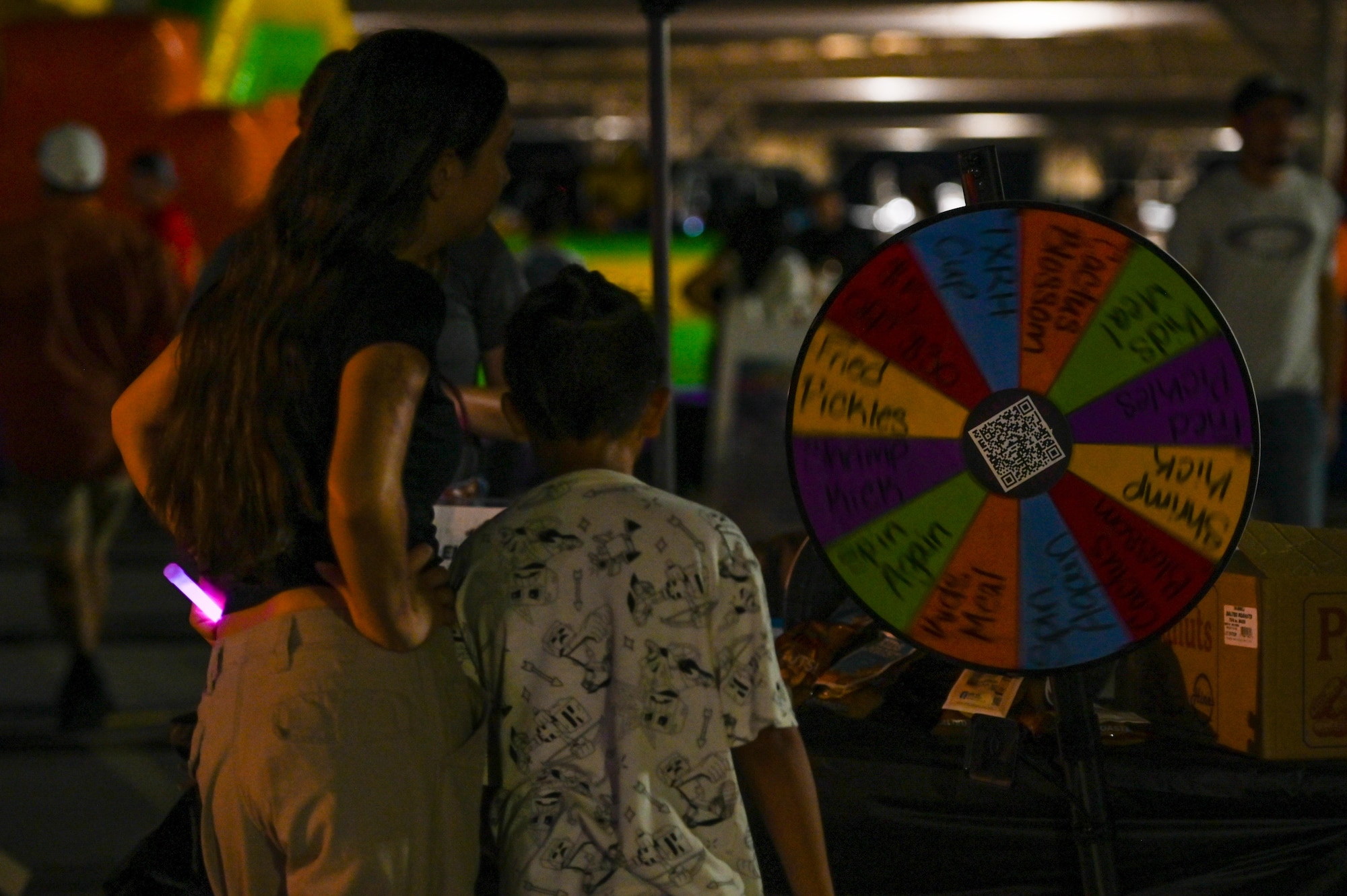 Attendees spin a wheel at a local vendor booth during Summer Bash at Laughlin Air Force Base, Texas, Sept. 15, 2025. The event was open to LAFB active-duty members, civilians, contractors and surrounding communities as a farewell to the summer season. (U.S. Air Force photo by Senior Airman Jarrett Smith)