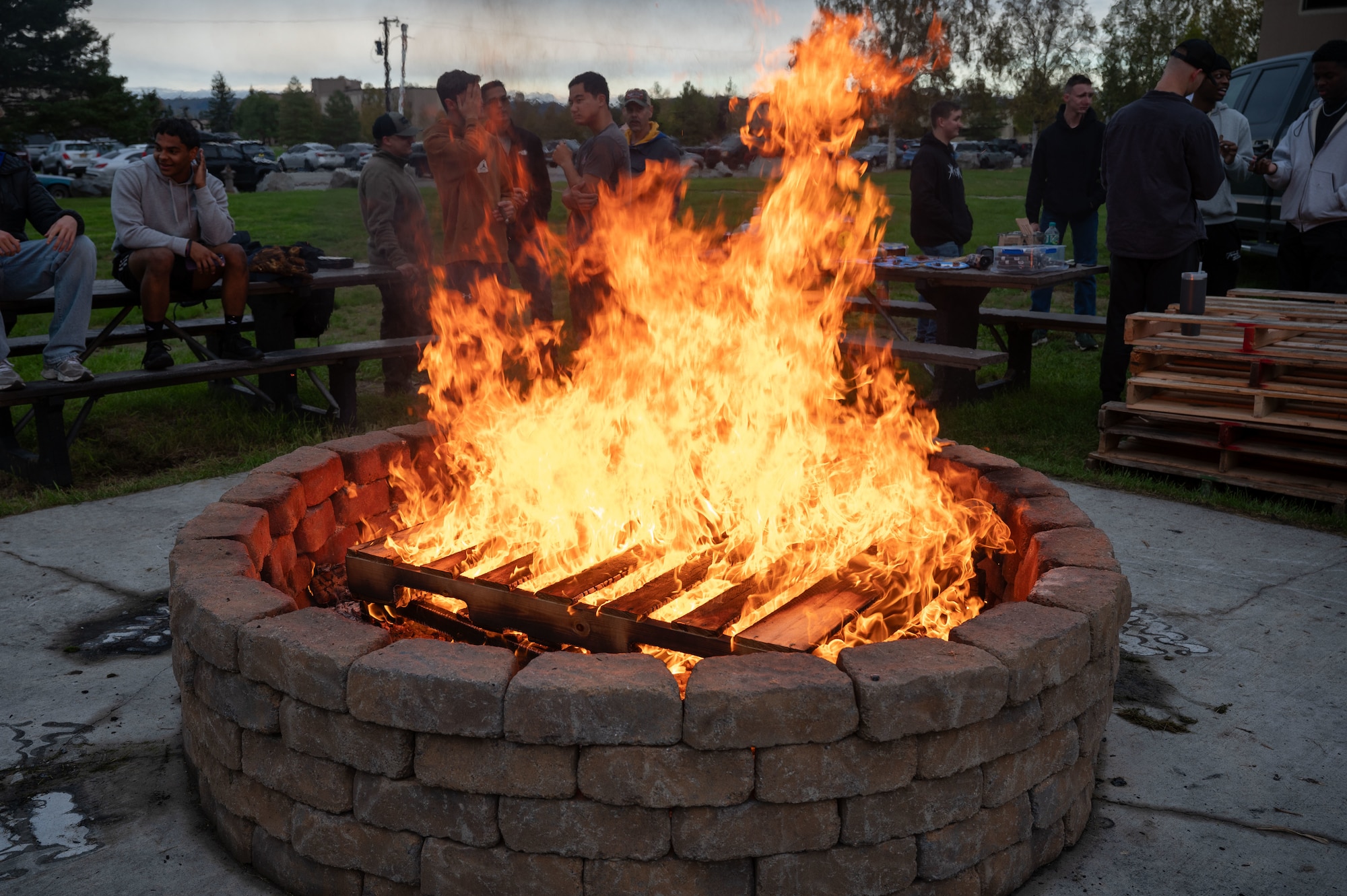 Airmen assigned to the 354th Fighter Wing gather around a fire during the one-year anniversary of Holy Smokes at Eielson Air Force Base, Alaska, Sept. 12, 2025.