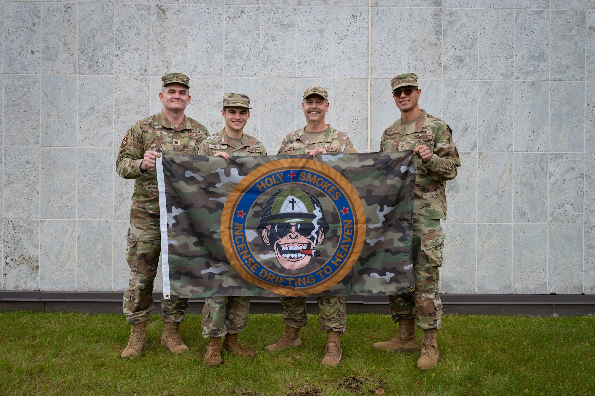 U.S. Air Force Maj. James Hughes and Maj. Mark Hill, 354th Fighter Wing chaplains, Master Sgt. Jorge Garcia-Gonzalez, 354th FW chaplain superintendent, and Senior Airman Zachary Meier, 354th Contracting Squadron contracting specialist, pose for a photo before the one-year anniversary of Holy Smokes at Eielson Air Force Base, Alaska, Sept. 12, 2025.