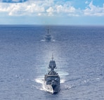 Arleigh Burke-class guided-missile destroyer USS Dewey (DDG 105), back, sails alongside Anzac-class frigate HMAS Ballarat (FFH 155), front, during a bilateral training with the Royal Australian Navy in the South China Sea, Sept. 16, 2025.