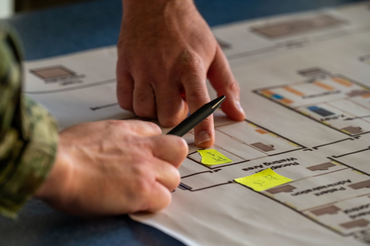Participants point to a Role 2 facility map during a global health engagement at the Military Medical Center in Zagreb