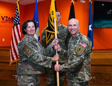 U.S. Space Force (USSF) Space Systems Command’s (SSC) stands up Systems Delta 81 (SYD 81) at Peterson Space Force Base, Colo. on Sept. 9, 2025. USAF Brig. Gen. Michelle Idle, mobilization assistant to the SSC commander, passes the SYD 81 guidon to USSF Col. Corey Klopstein, SYD 81 Commander. (USAF Photo by Senior Airman William Pugh)