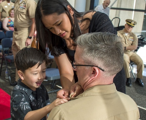 A Family Pinning…Chief Hospital Corpsman Miles Steele takes a knee for family to affix his Navy chief petty officer anchors as part of Navy Medicine Readiness Training Command Bremerton Chief Petty Officer Pining Ceremony, Sept. 16, 2025, in front of command leadership, staff members, patients, family, friends and the NMRTC Bremerton Chiefs Mess, past, present and future. The pinning ceremony is the culmination of six weeks of chief’s initiation training for Steele, along with Chief Hospital Corpsmen Jessie Christian Alday, Lee Halls, Robert Lee O’Bryant, and Chief Logistics Specialist Steven Alexander Gardiner (Official Navy photo by Mass Communication Specialist 2nd Class Jennifer Benedict, NHB/NMRTC Bremerton public affairs).