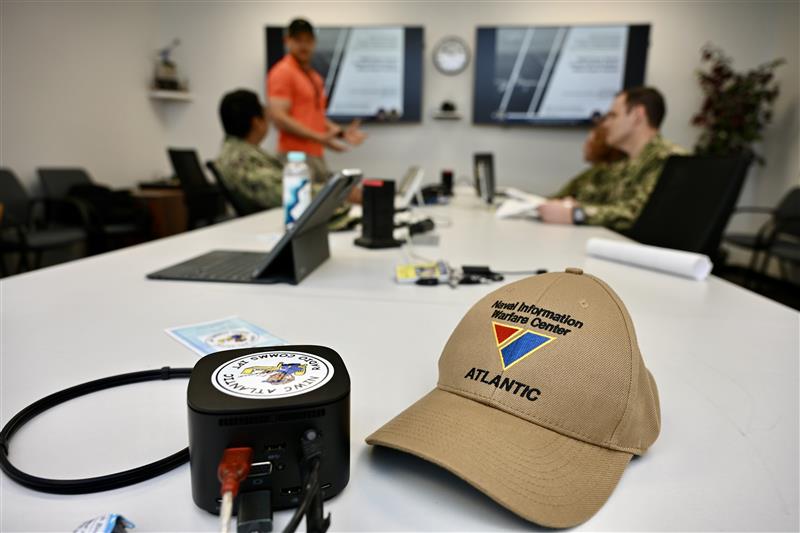 A Navy Reservist is focused on performing maintenance or troubleshooting on electronic equipment within a lab. The setting suggests hands-on training.