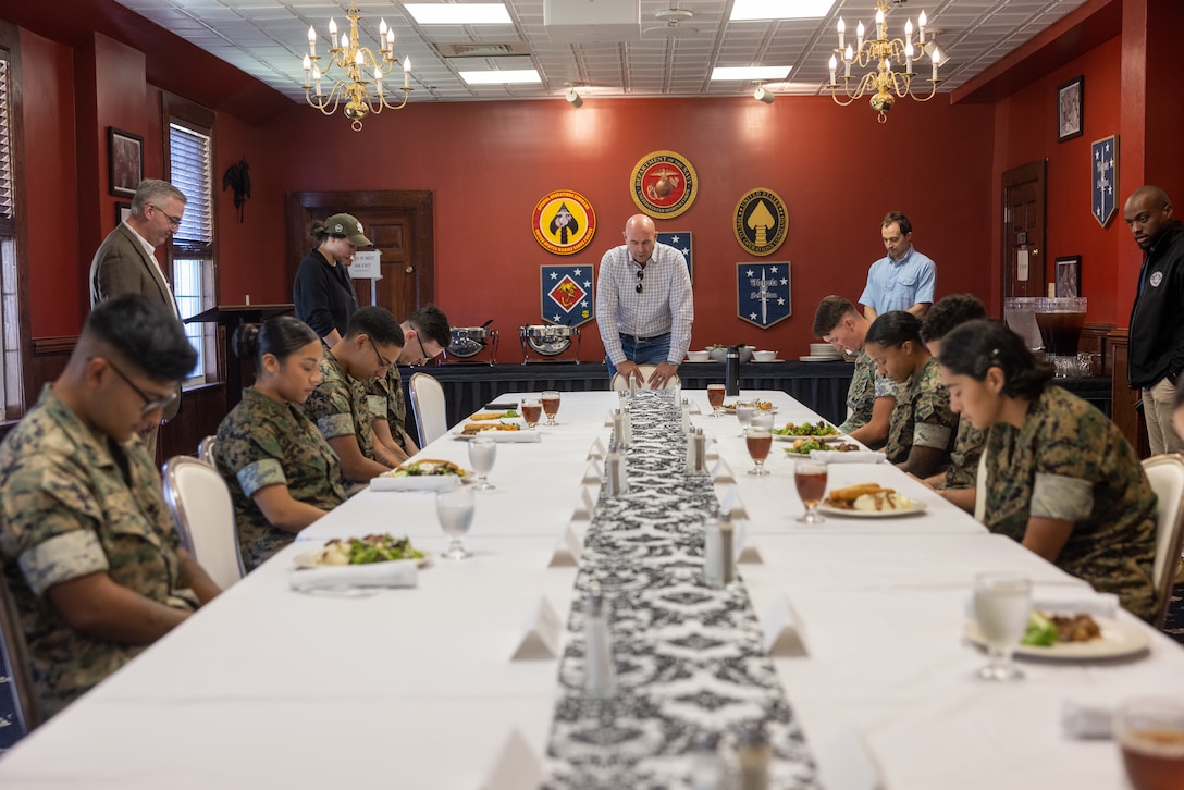Congressman Jake Ellzey, center, (TX-06), prays at a luncheon with Marines and House representatives during a bipartisan congressional delegation (CODEL) on Marine Corps Base Camp Lejeune, North Carolina, Sept. 12, 2025. The delegation of Representatives was held to inform the For Country Caucus on updates to Force Design 2030, quality of life issues and aerial refueling initiatives. (U.S. Marine Corps photo by Lance Cpl. Alyssa DeCrane)