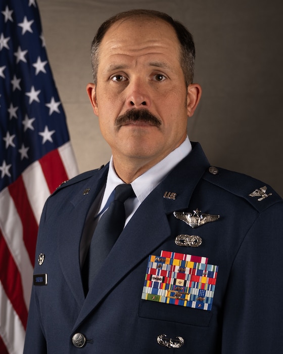 Portrait of a male Air Force service member wearing a service dress uniform and a mustache.