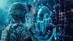 A U.S. Soldier in camouflage uniform and tactical gear looks at a large digital display showing a glowing map of the world with blue cyber-like graphics and data overlays, symbolizing cyber warfare or digital defense operations.