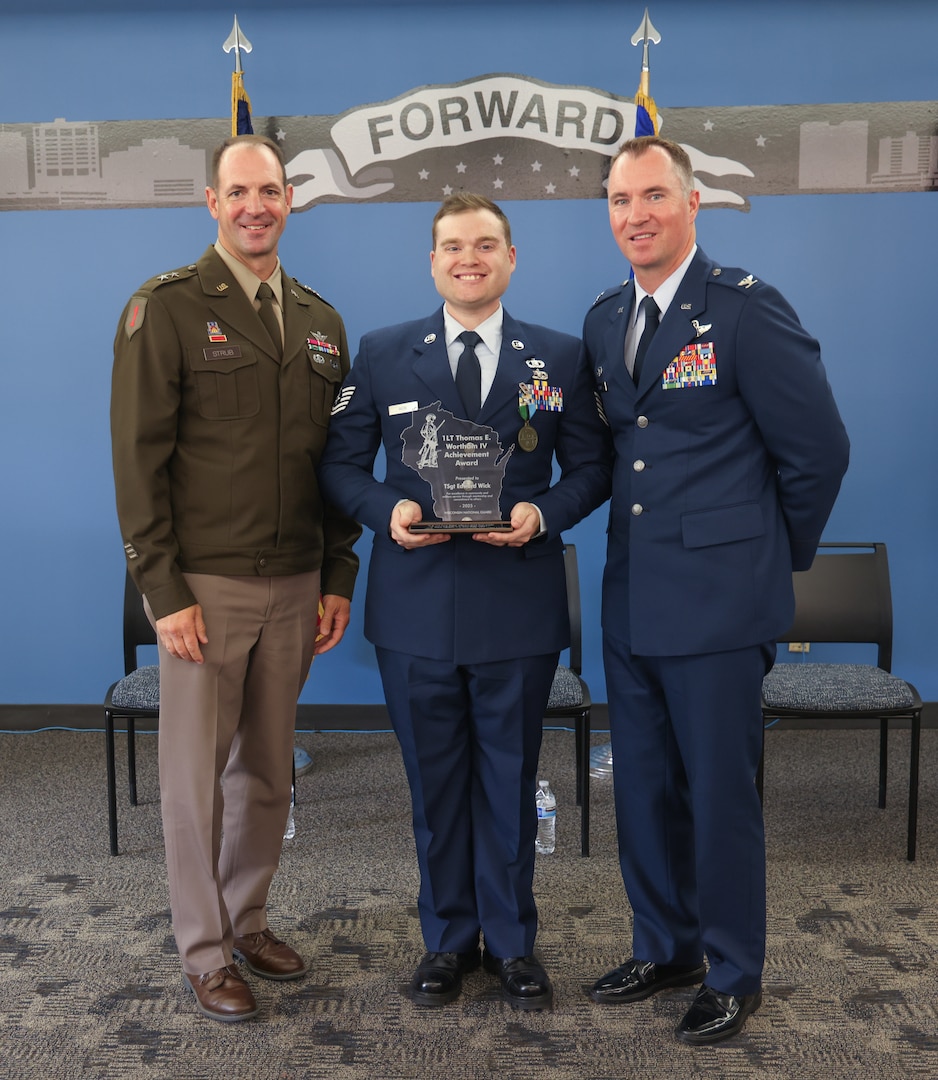 U.S. Air Force Tech. Sgt. Edward Wick, center, a munitions controller with the 115th Fighter Wing, Wisconsin Air National Guard, is recognized as the 2024 1st. Lt. Thomas E. Wortham IV Achievement Award recipient by U.S. Army Maj. Gen. Matthew J. Strub, left, Wisconsin’s adjutant general, and U.S. Air Force Col. Benjamin M. Gerds, the 115th Fighter Wing commander, at Truax Field in Madison, Wisconsin, Sept. 11, 2025. Wick received the award for excellence in his community and his military service through mentorship and commitment to others. (U.S. Air National Guard photo by Staff Sgt. Olivia Sherman)