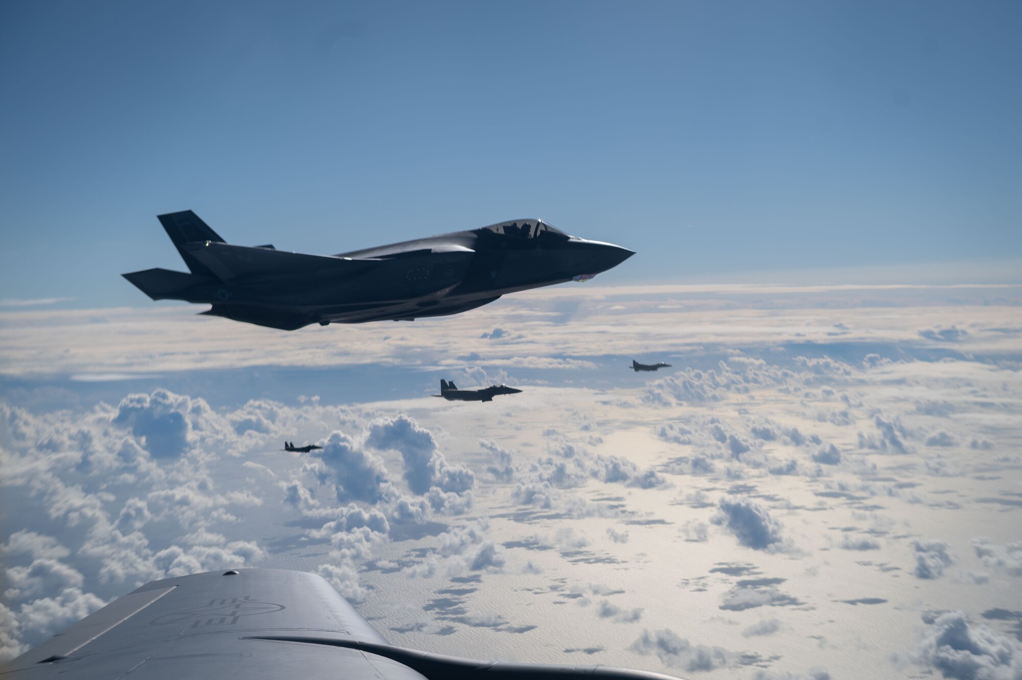 Four U.S. Air Force F-35A Lightning IIs from the 48th Fighter Wing at RAF Lakenheath, fly alongside a KC-135 Stratotanker from the 100th Air Refueling Wing after receiving fuel during exercise Cobra Warrior over the North Sea, Sept. 16, 2025.