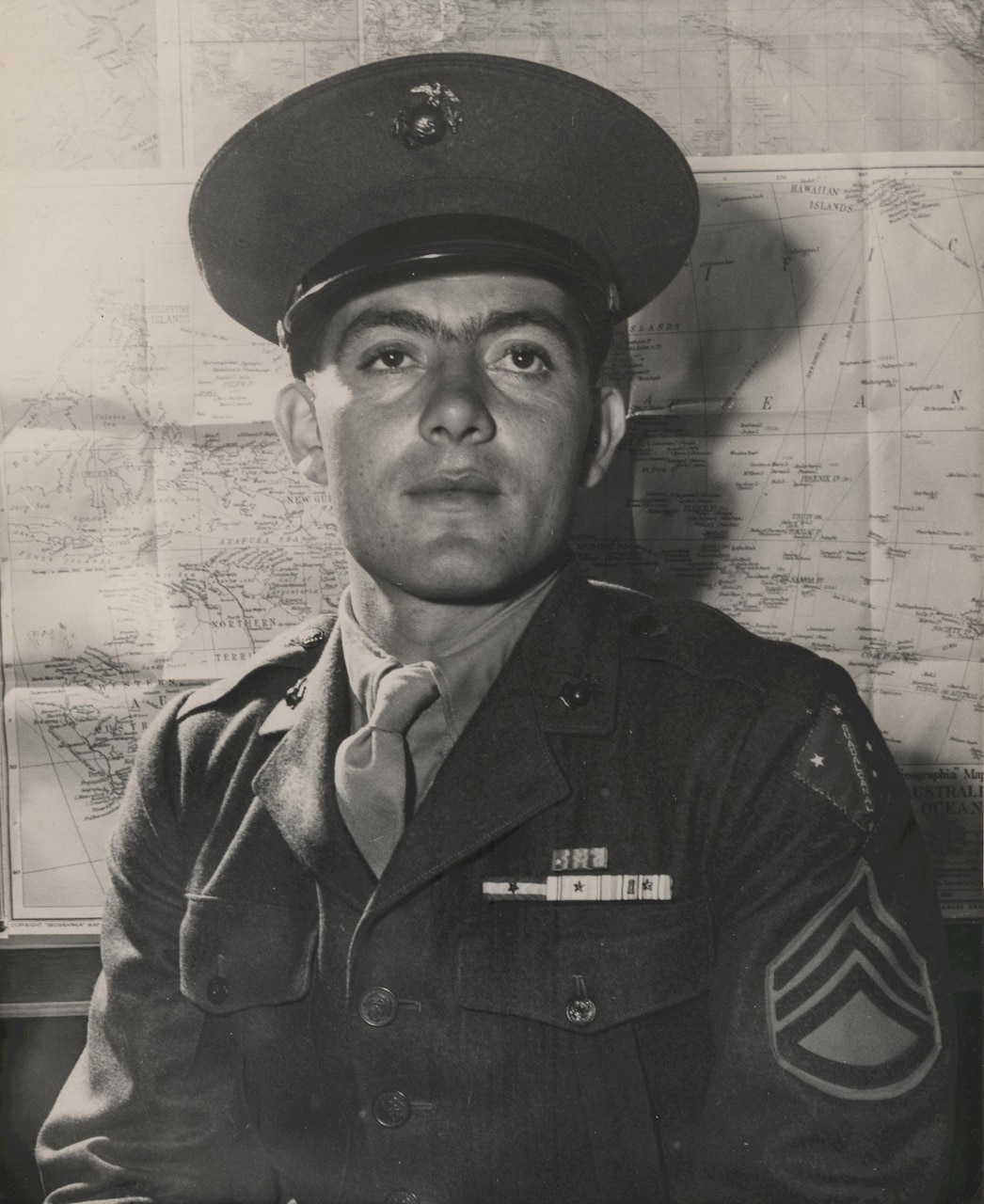 A Marine in uniform and wearing medals poses for a photo.